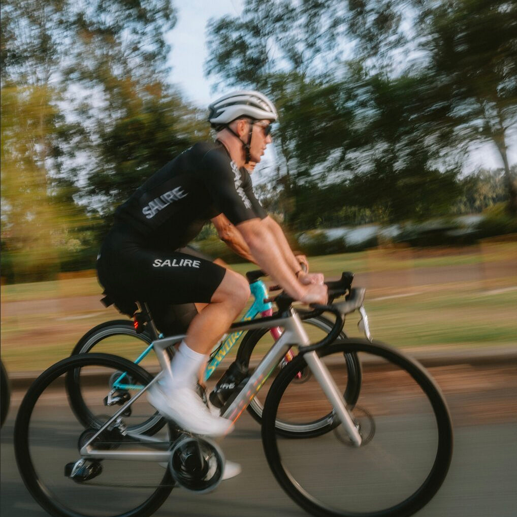 A cyclist in Salire black jersey and black bibs