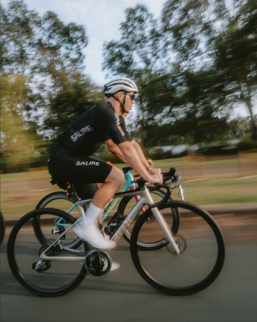 A cyclist in Salire black jersey and black bibs