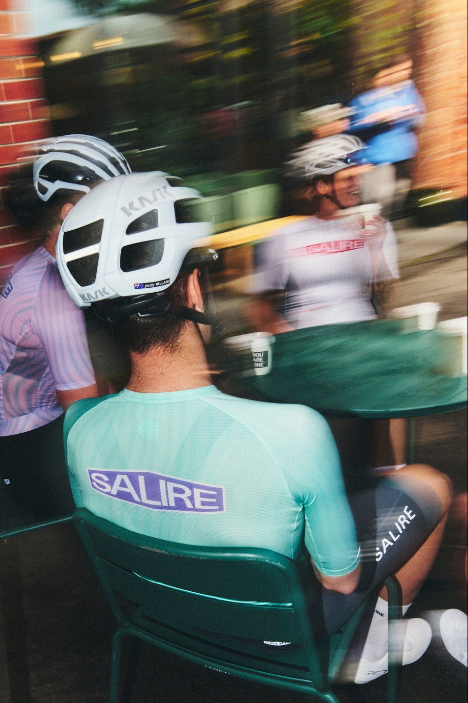 Three cyclists wearing Salire kits and enjoying their drinks