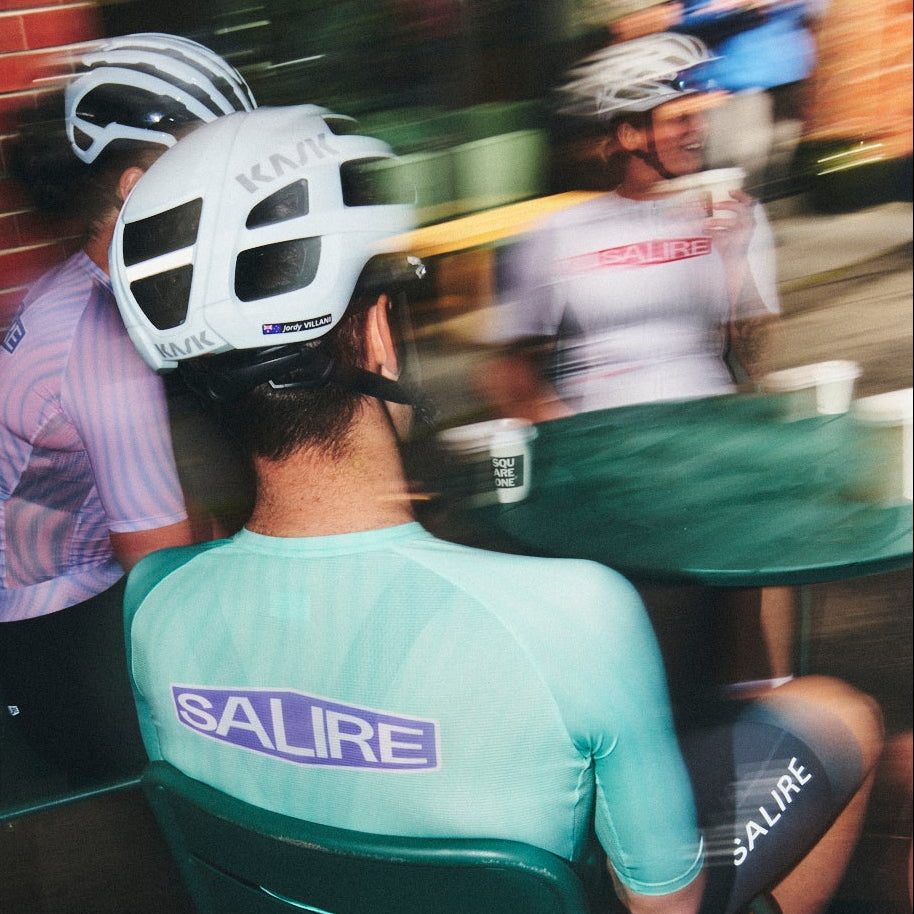 Three cyclists wearing Salire kits and enjoying their drinks