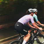 Two cyclists riding on a road with a blurred background
