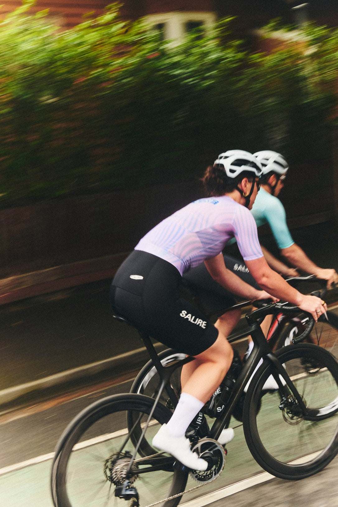 Two cyclists riding on a road with a blurred background